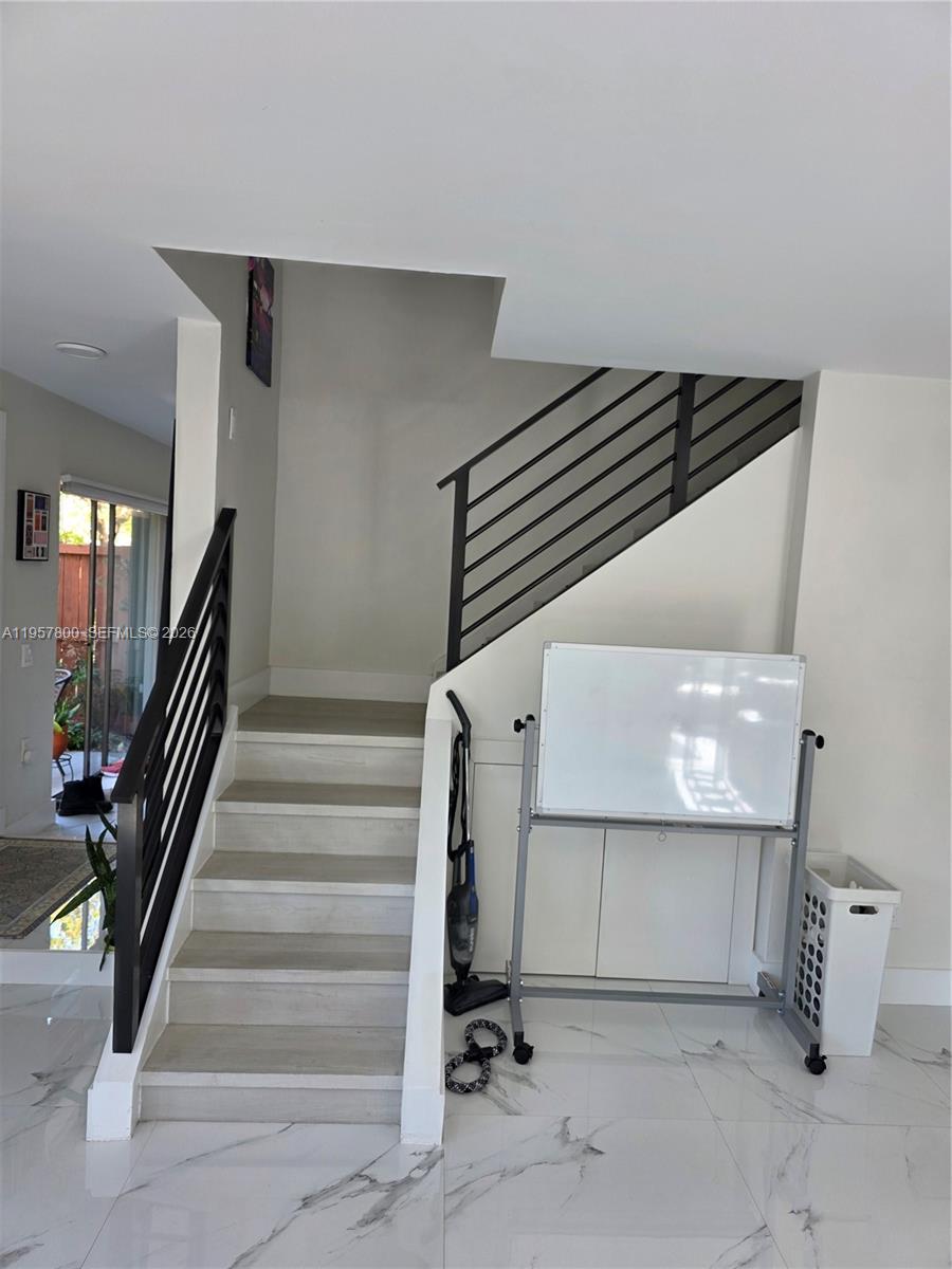 6904 Southwest 114th Place, Unit C58 Miami, FL 33173 - Photo 20 of 27 modern staircase dividing kitchen/dining areas and living room