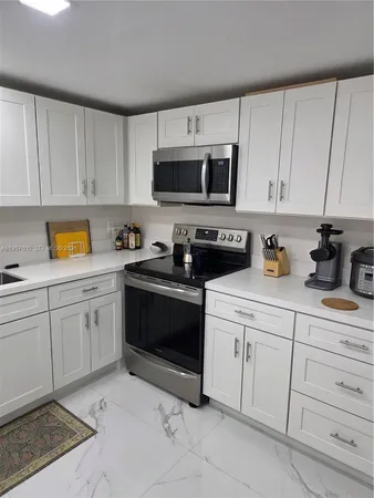 a kitchen with white cabinets and white appliances