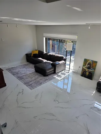 a living room with a couch and a dresser next to a window
