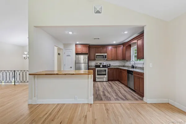 a view of kitchen with sink microwave and stove top oven