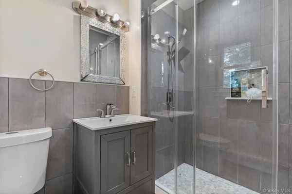 a view of an empty room with wooden floor and a ceiling fan