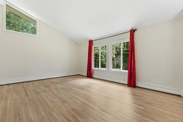 a view of a livingroom with wooden floor and a window
