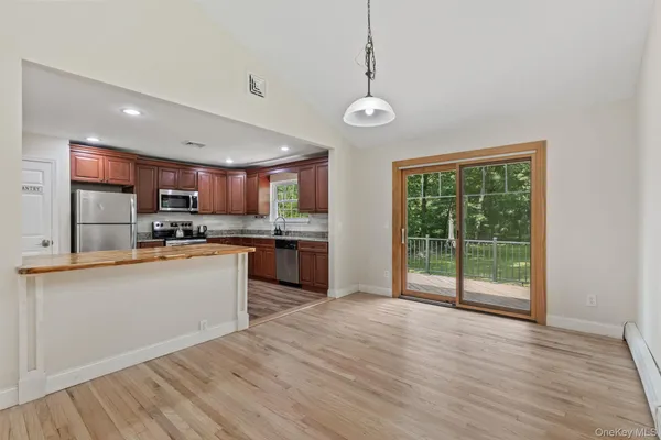 a view of empty room with wooden floor and window