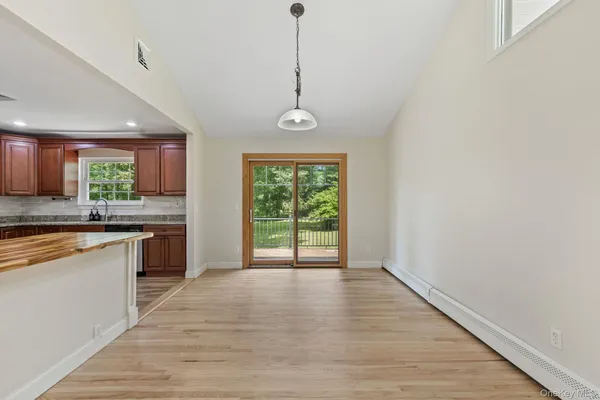 a kitchen with stainless steel appliances granite countertop a refrigerator a sink dishwasher a stove and a wooden floors