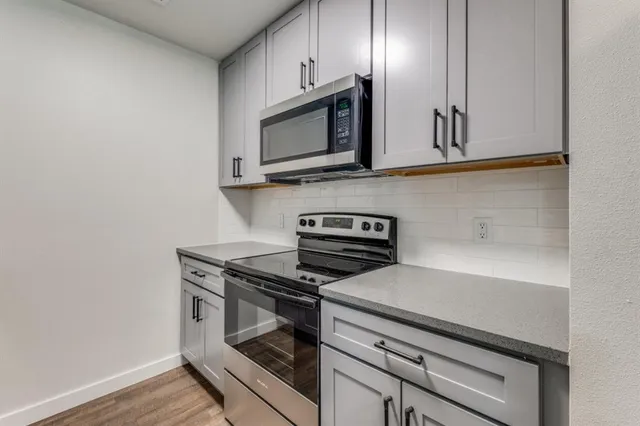 a kitchen with stainless steel appliances a stove microwave and sink