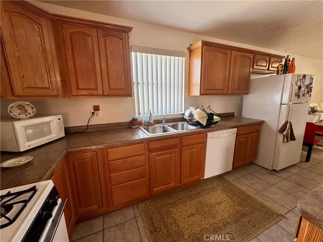 a kitchen with stainless steel appliances a stove top oven a sink dishwasher and a refrigerator