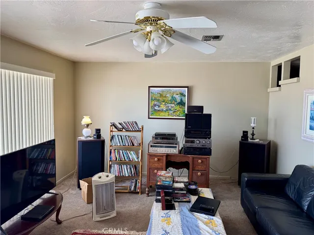 a living room with furniture a flat screen tv and a window