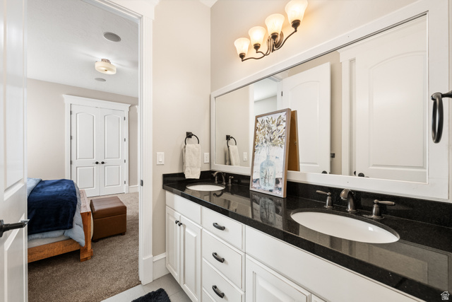 1205 North Elk Rdg Lane, Unit 202 Alpine, UT 84004 - Photo 47 of 88 Dual vanity featuring a dark countertop, white cabinetry with dark hardware, and two undermount sinks