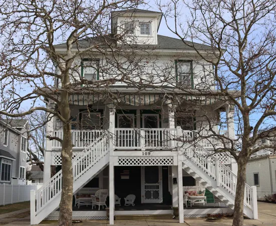 a front view of a building with large trees