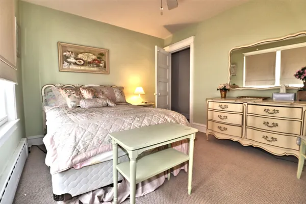 a bedroom with a bed a chandelier and dresser