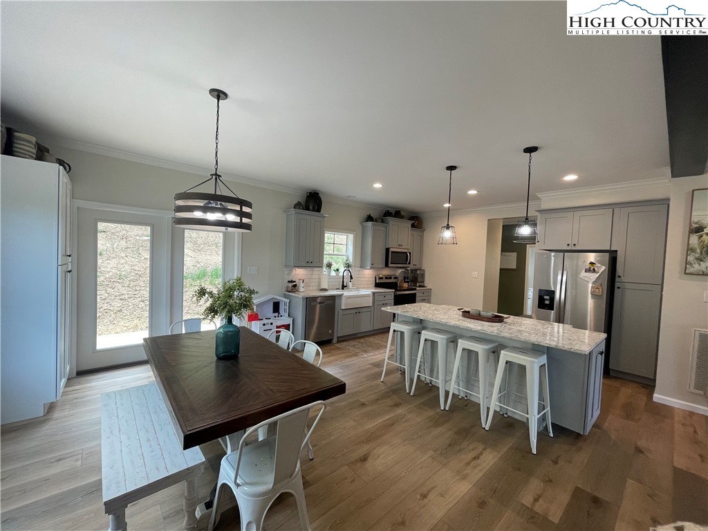 878 Ballou Farm Road Crumpler, NC 28617 - Photo 22 of 45 a view of a dining room and livingroom with furniture wooden floor a chandelier