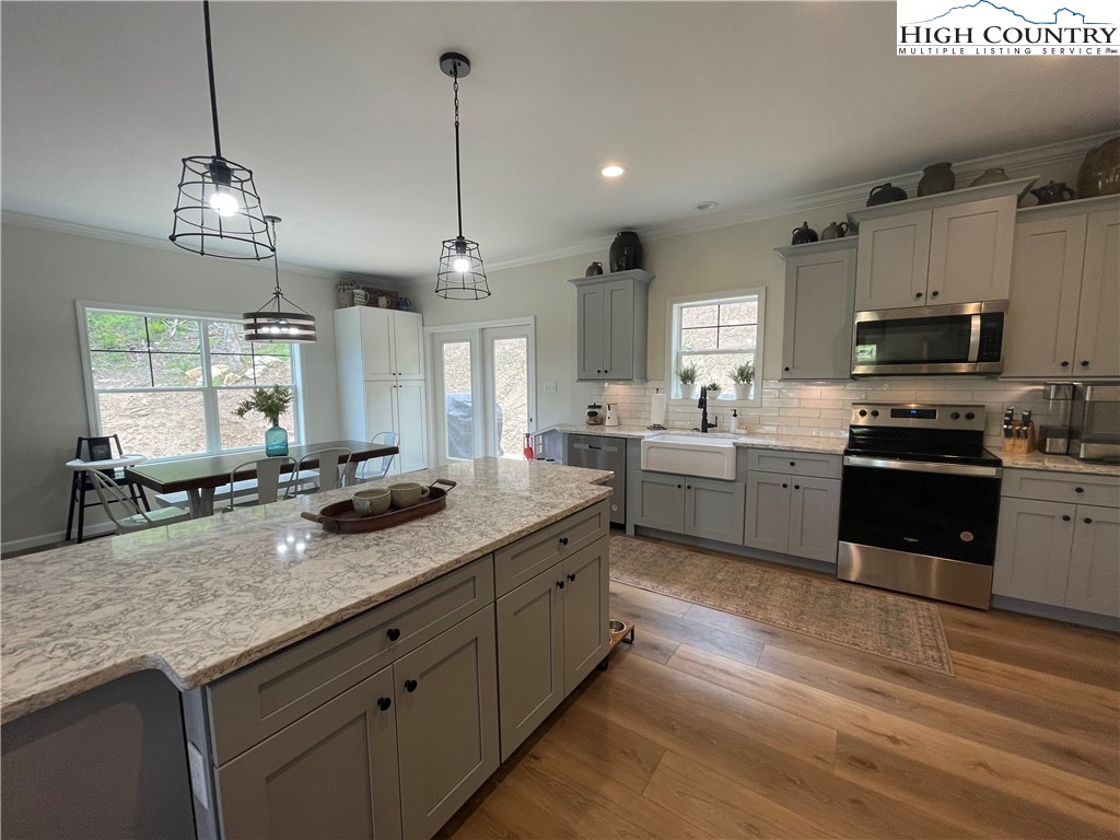 878 Ballou Farm Road Crumpler, NC 28617 - Photo 24 of 45 a kitchen with stainless steel appliances granite countertop a sink a stove and a wooden floors