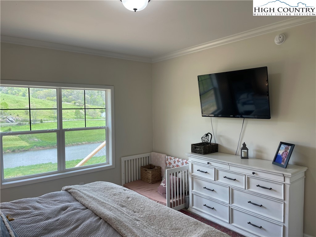 878 Ballou Farm Road Crumpler, NC 28617 - Photo 29 of 45 a bedroom with a bed and a flat screen tv