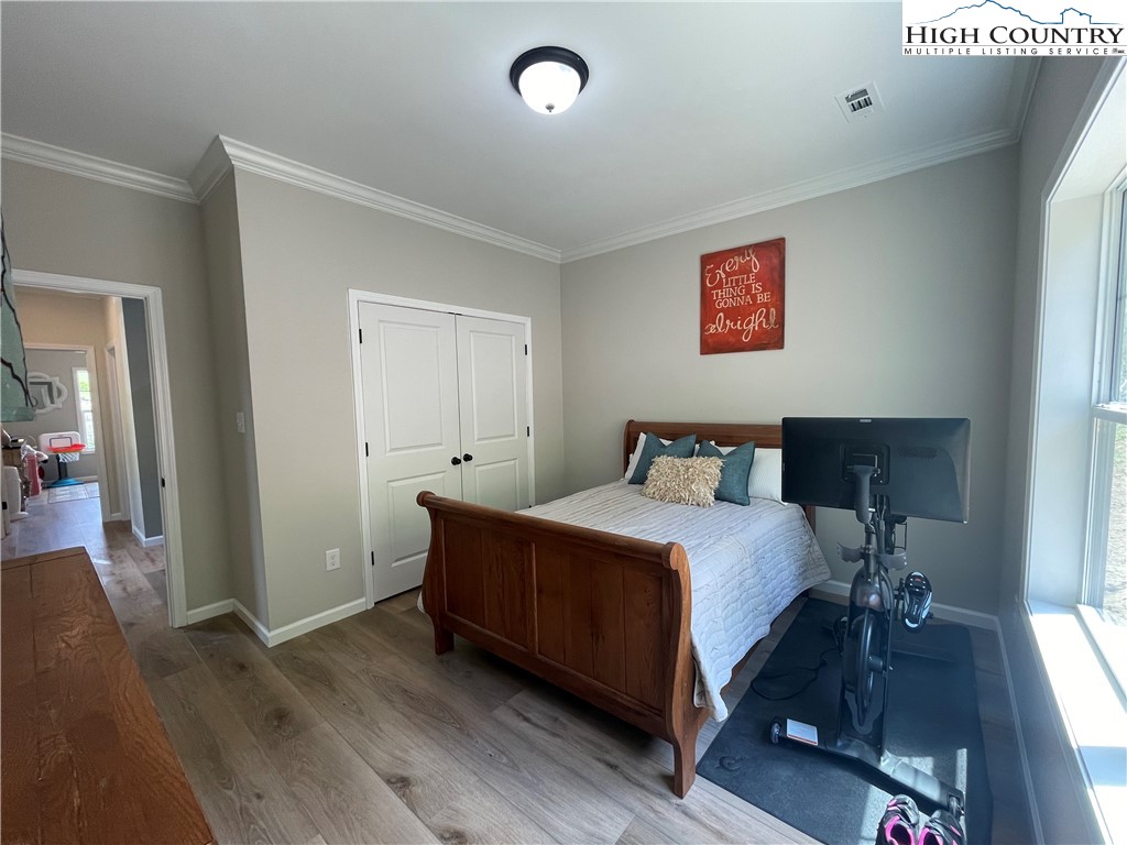 878 Ballou Farm Road Crumpler, NC 28617 - Photo 39 of 45 a spacious bedroom with a bed and wooden floor