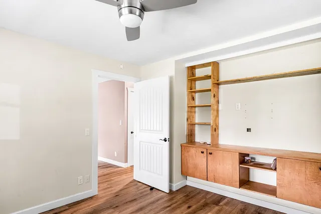 an empty room with wooden floor and cabinet