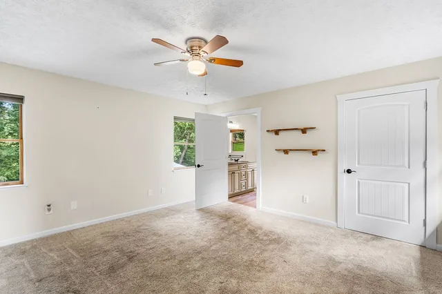an empty room with closet and windows