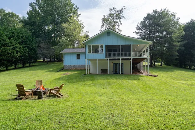 a view of a house with a yard and large tree