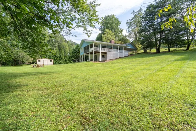an aerial view of a house with swimming pool and trees
