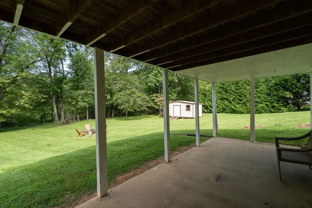 a front view of a house with a yard and trees