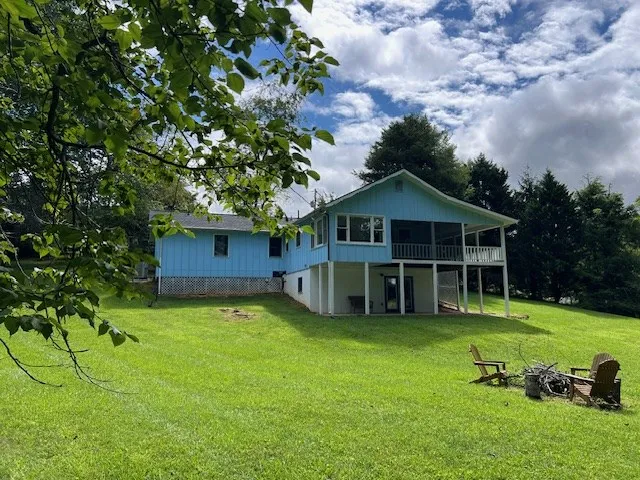 a view of a house with a yard potted plants and large tree