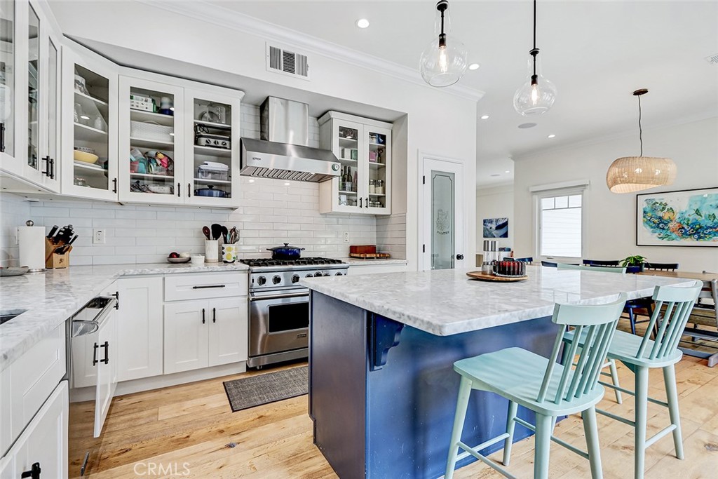 825 Center Street El Segundo, CA 90245 - Photo 4 of 52 a kitchen with stainless steel appliances granite countertop a stove a sink dishwasher a oven a dining table and chairs with wooden floor