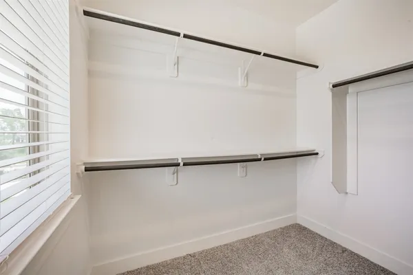 a view of small space with racks on the wall and a window