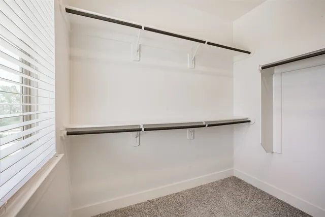 a view of small space with racks on the wall and a window