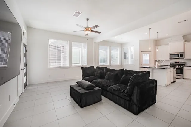 a living room with furniture and kitchen view