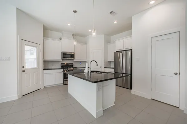 a kitchen with stainless steel appliances granite countertop a refrigerator and a sink