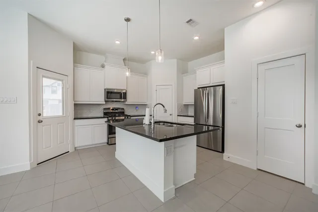 a kitchen with stainless steel appliances granite countertop a refrigerator and a sink