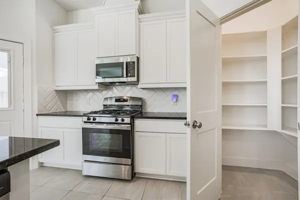 a kitchen with stainless steel appliances granite countertop a stove and a microwave