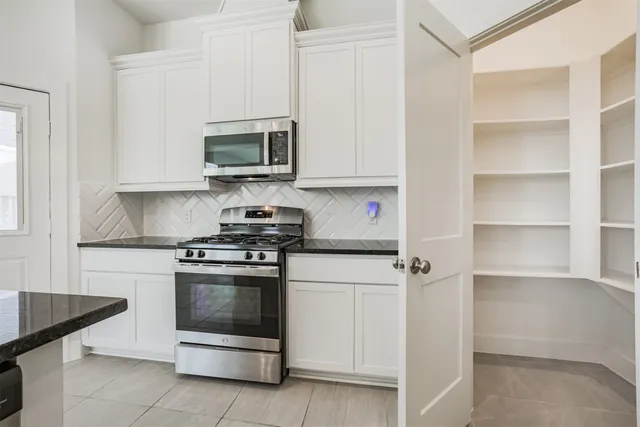 a kitchen with stainless steel appliances granite countertop a stove and a microwave