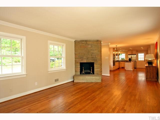 100 Byron Place Raleigh, NC 27609 - Photo 2 of 12 Living room with wood burning stone fire place is open to the dining room and kitchen features newly finished hardwood floors. Living Room