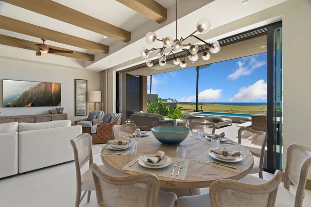 a view of a dining room with furniture a chandelier and large window