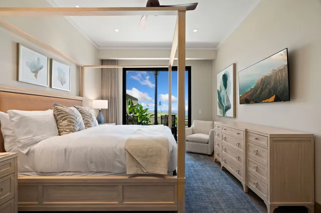 a bedroom with a large bed and a flat tv screen on dresser