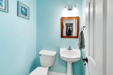 a bathroom with a toilet a sink and mirror