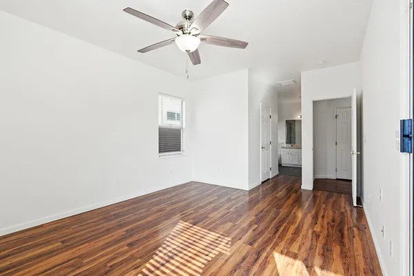 a view of a big room with wooden floor a ceiling fan and closet