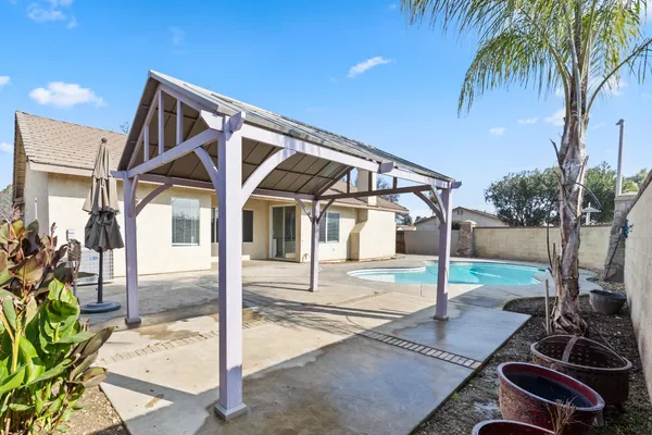a view of a house with backyard and sitting area