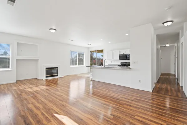 a view of a kitchen with furniture and wooden floor