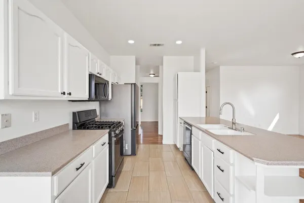 a kitchen with white cabinets sink and stainless steel appliances