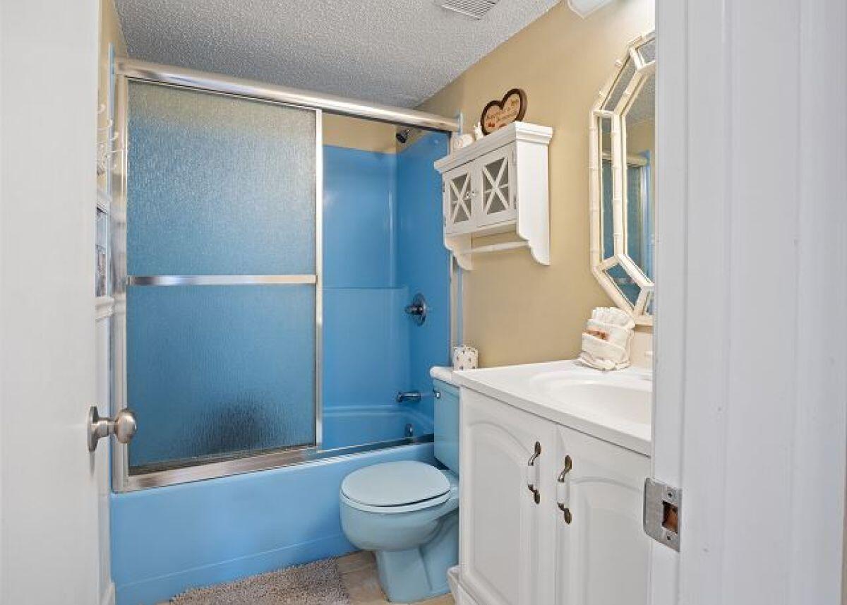 909 Santa Rosa Boulevard, Unit 211 Fort Walton Beach, FL 32548 - Photo 14 of 21 a bathroom with a sink a toilet a mirror and shower