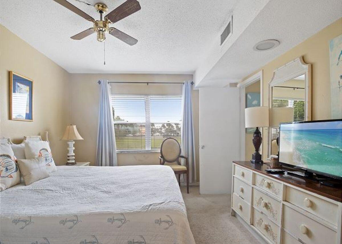 909 Santa Rosa Boulevard, Unit 211 Fort Walton Beach, FL 32548 - Photo 10 of 21 a bedroom with a bed and a flat screen tv