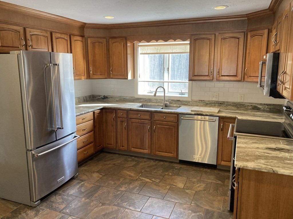 65 Purgatory Road Sutton, MA 01590 - Photo 12 of 40 a kitchen with stainless steel appliances granite countertop a refrigerator sink and cabinets