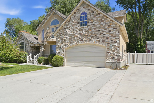 883 East 700 South Springville, UT 84663 - Photo 3 of 59 Stone and stucco facade featuring a two-car garage with an arched stone surround