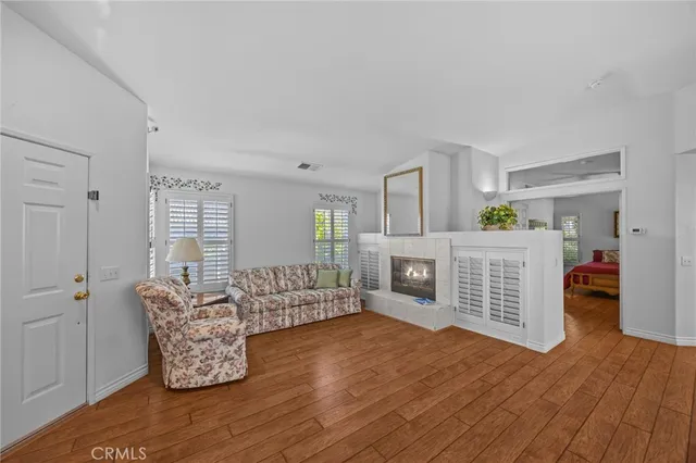 a living room with furniture a flat screen tv and a wooden floor