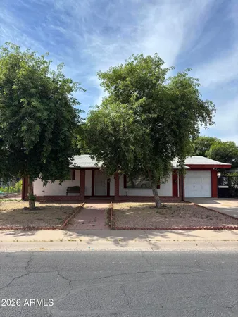 a view of a house with a yard and large trees