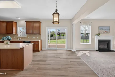 a kitchen with stainless steel appliances granite countertop a refrigerator a sink a stove a microwave and wooden floors