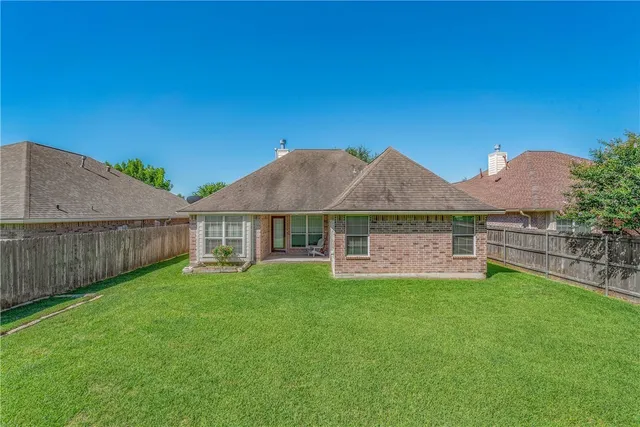 a view of a house with a yard and sitting area