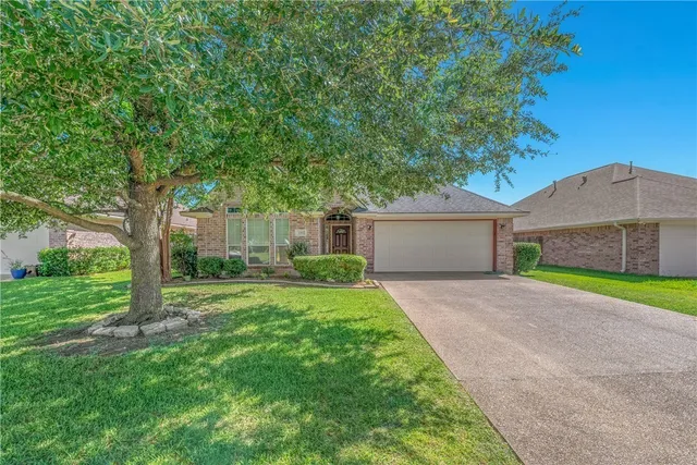 a front view of a house with a yard and a garage