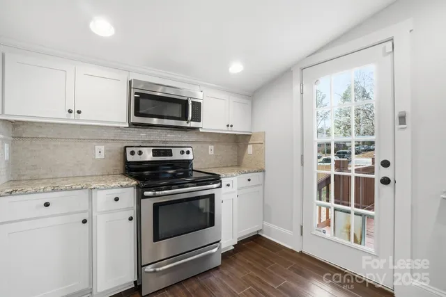 a kitchen with stainless steel appliances granite countertop a stove and a microwave